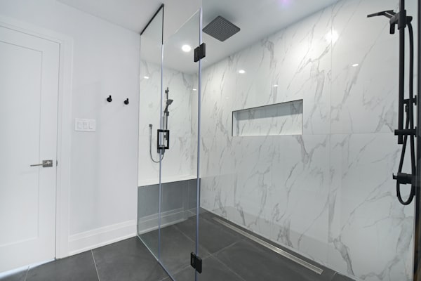 Modern bathroom with glass-enclosed shower and marble walls